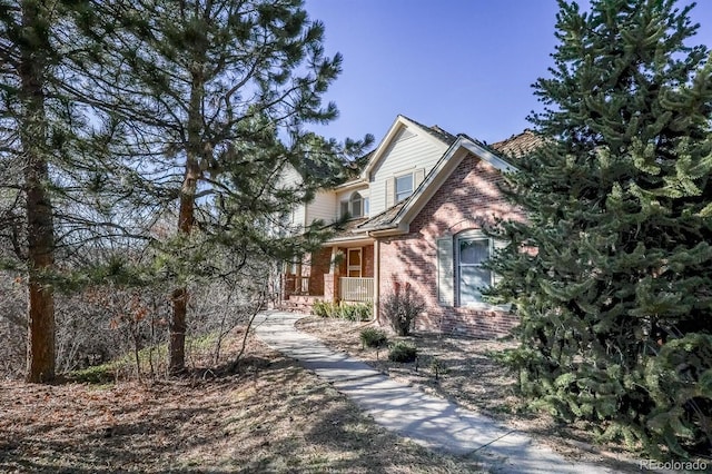 view of front of house with brick siding and a porch