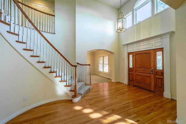 entrance foyer featuring plenty of natural light, wood finished floors, and arched walkways