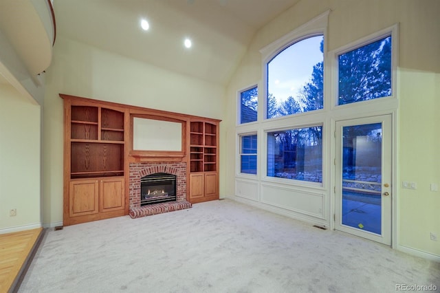 unfurnished living room featuring visible vents, carpet, a brick fireplace, and high vaulted ceiling