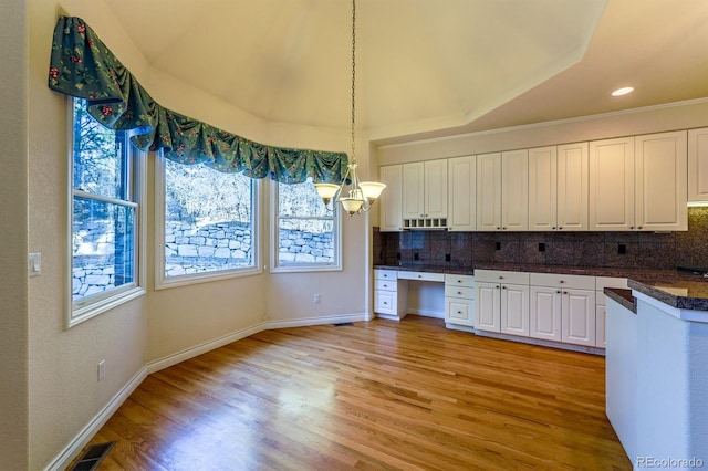 kitchen featuring light wood-style floors, backsplash, and white cabinets