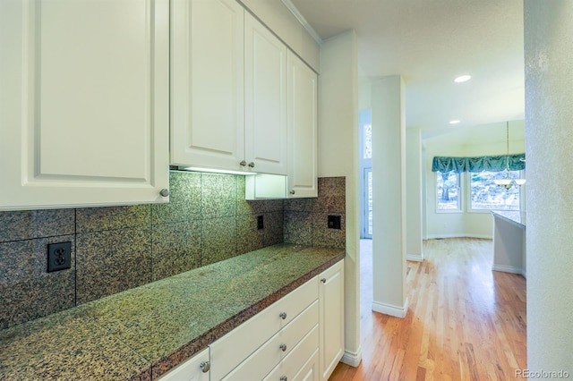 kitchen with light wood-type flooring, tasteful backsplash, recessed lighting, white cabinets, and baseboards