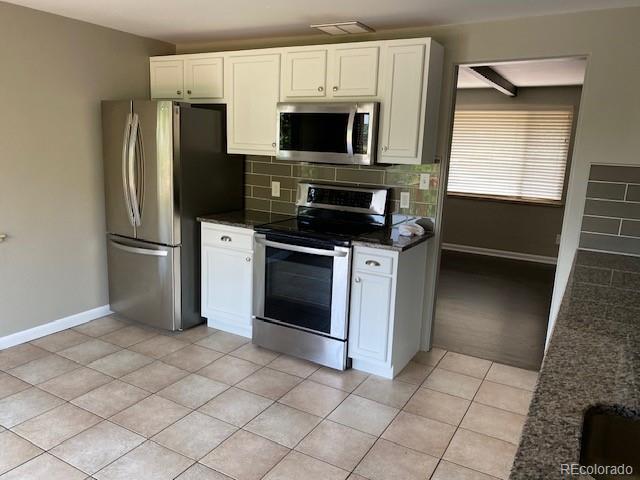 217 Ford St, Golden, CO 80403 - kitchen with stainless steel appliances, baseboards, decorative backsplash, and white cabinets