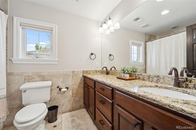 1317 S Saint Paul St, Denver, CO 80210 - full bath with toilet, tile walls, wainscoting, and double vanity