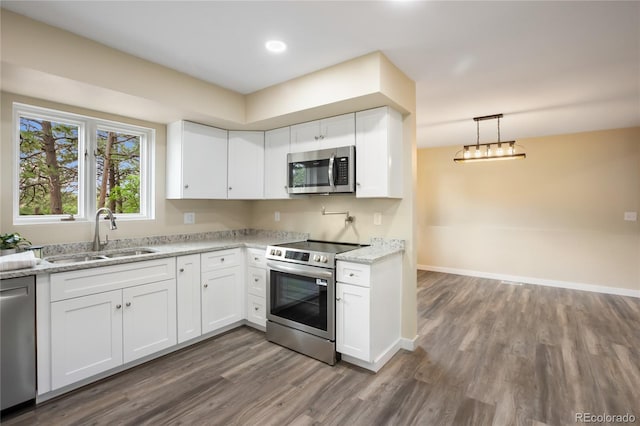595 Wintery Cir, Colorado Springs, CO 80919 - kitchen with stainless steel appliances, a sink, dark wood-type flooring, white cabinetry, and recessed lighting