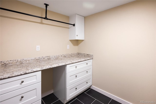 595 Wintery Cir, Colorado Springs, CO 80919 - kitchen with white cabinets, dark tile patterned flooring, light countertops, and baseboards