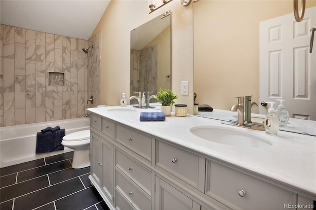 595 Wintery Cir, Colorado Springs, CO 80919 - bathroom featuring double vanity, toilet, tile patterned floors, vaulted ceiling, and washtub / shower combination