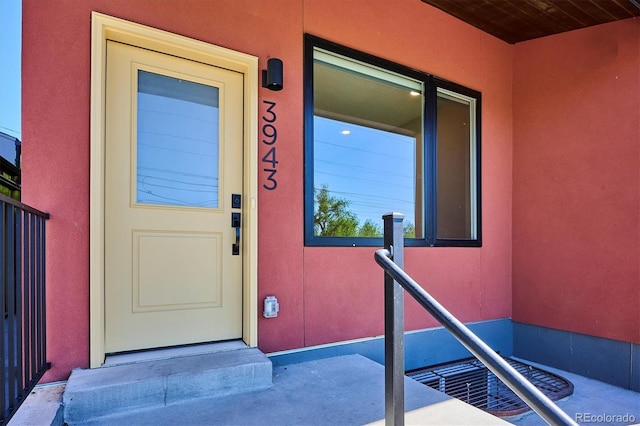 doorway to property featuring stucco siding