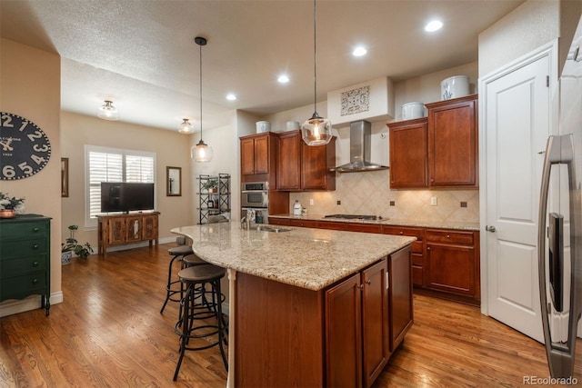 9165 Kornbrust Dr, Lone Tree, CO 80124 - kitchen featuring wall chimney exhaust hood, a sink, wood finished floors, a kitchen bar, and backsplash