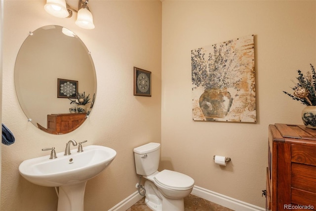 9165 Kornbrust Dr, Lone Tree, CO 80124 - half bathroom with baseboards, toilet, a sink, and tile patterned floors