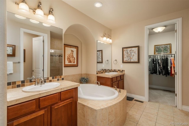 9165 Kornbrust Dr, Lone Tree, CO 80124 - full bath featuring two vanities, a bath, tile patterned flooring, tiled shower, and baseboards