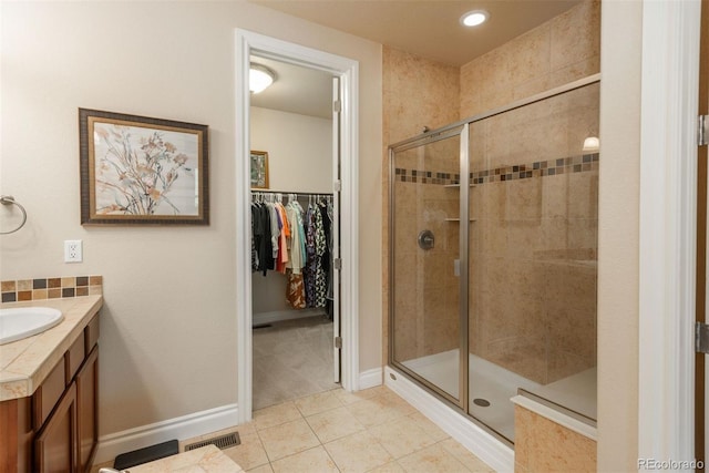9165 Kornbrust Dr, Lone Tree, CO 80124 - bathroom featuring a shower stall, tile patterned flooring, a walk in closet, vanity, and recessed lighting