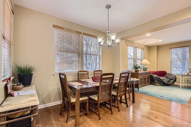 dining area featuring wood-type flooring and a notable chandelier