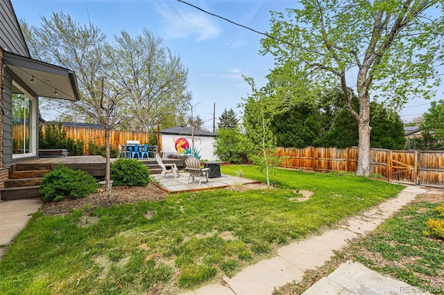 view of yard with an outdoor structure, a patio, and a deck