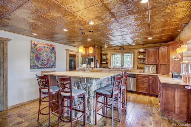 1198 Kootchie Kootchie Rd, Alma, CO 80420 - kitchen featuring stainless steel dishwasher, decorative light fixtures, a center island, wooden walls, and hardwood / wood-style flooring