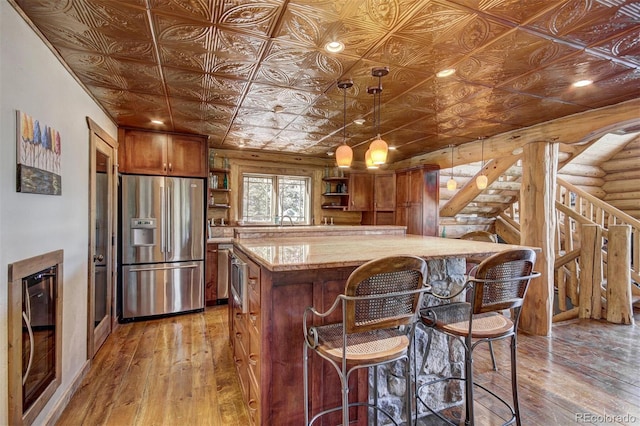 1198 Kootchie Kootchie Rd, Alma, CO 80420 - kitchen featuring hardwood / wood-style floors, hanging light fixtures, a center island, log walls, and stainless steel fridge with ice dispenser