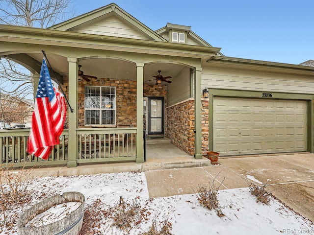 snow covered property entrance with a garage and a porch