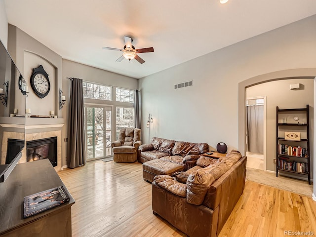 living room with light hardwood / wood-style flooring, a fireplace, and ceiling fan