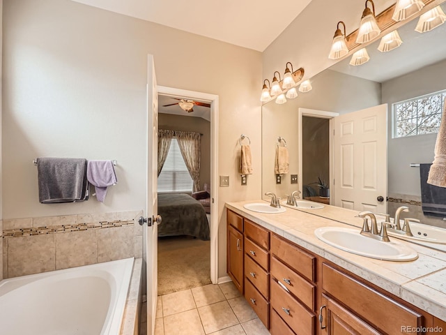 bathroom with a relaxing tiled tub, tile patterned floors, and vanity