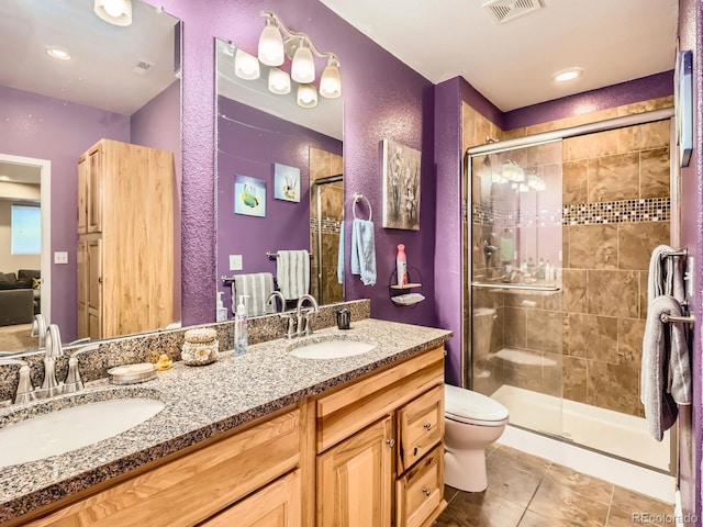 bathroom featuring vanity, toilet, an enclosed shower, and tile patterned flooring