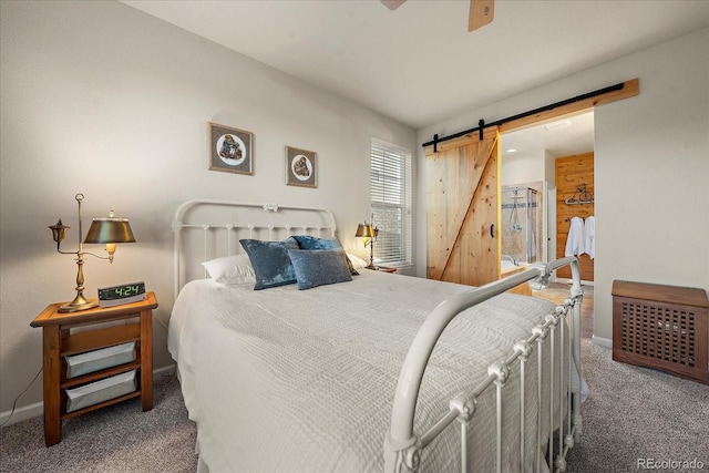 carpeted bedroom with ceiling fan and a barn door