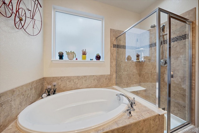 bathroom featuring independent shower and bath