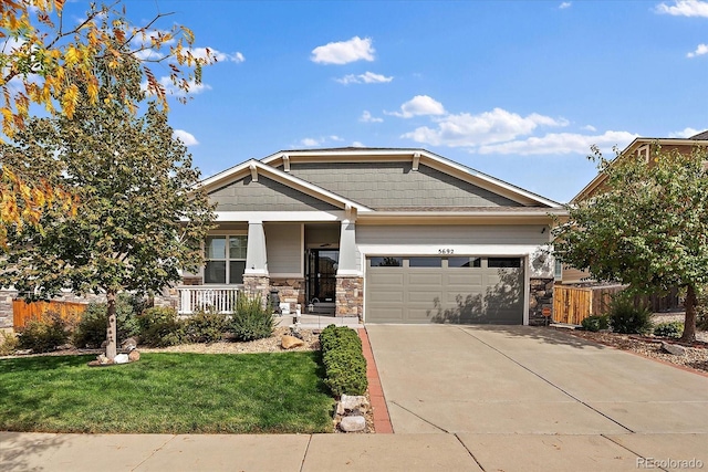 craftsman-style home featuring covered porch, a garage, and a front lawn