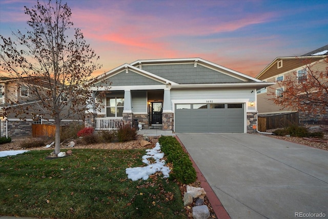 craftsman inspired home with a lawn, a porch, and a garage