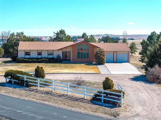 view of front facade featuring concrete driveway, an attached garage, a front yard, and a fenced front yard