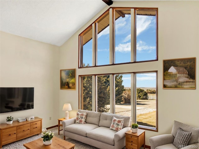 carpeted living area with baseboards and high vaulted ceiling