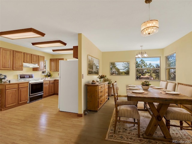 dining space featuring a notable chandelier and light wood-style flooring