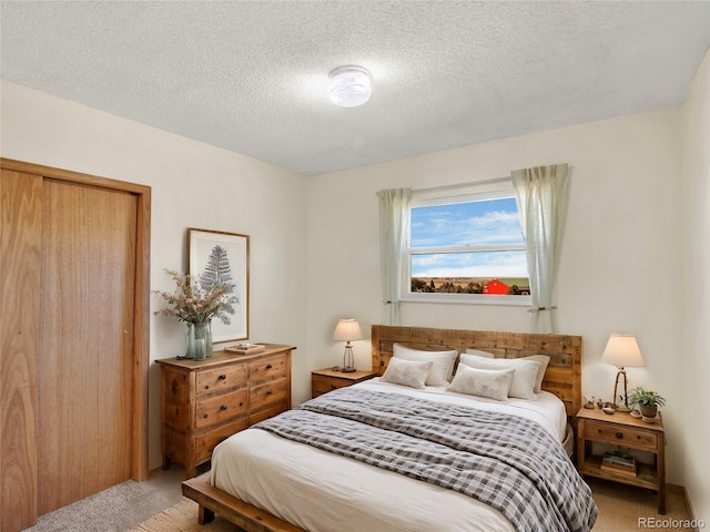 bedroom with a closet, carpet floors, and a textured ceiling