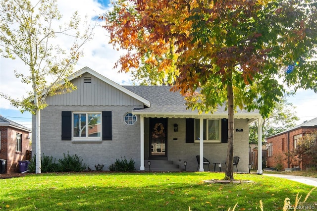 view of front of home featuring central AC unit, brick siding, a front lawn, and a shingled roof