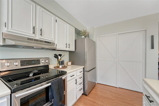 kitchen with white cabinetry, light countertops, light wood-type flooring, stainless steel appliances, and under cabinet range hood