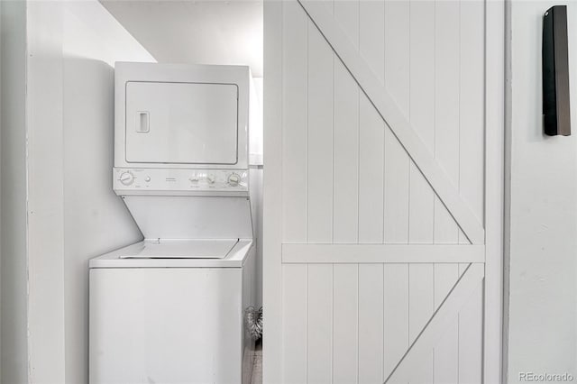 laundry room featuring stacked washer / drying machine and laundry area
