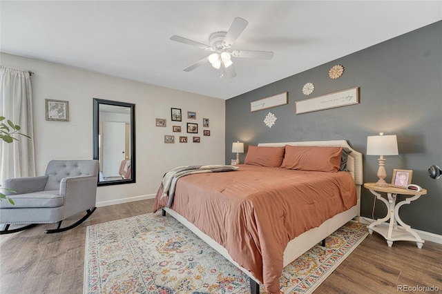 bedroom with baseboards, wood finished floors, and a ceiling fan