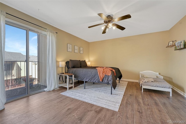 bedroom with baseboards, access to exterior, wood finished floors, and a ceiling fan
