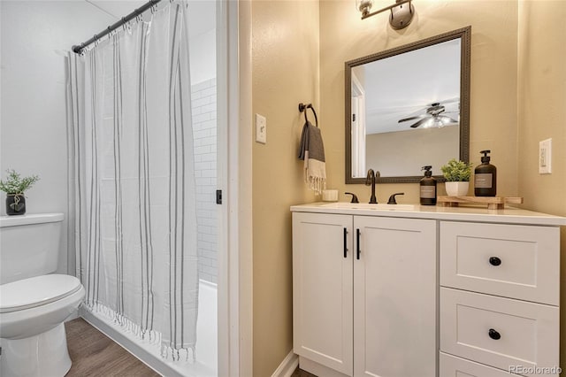 bathroom with wood finished floors, toilet, ceiling fan, and vanity