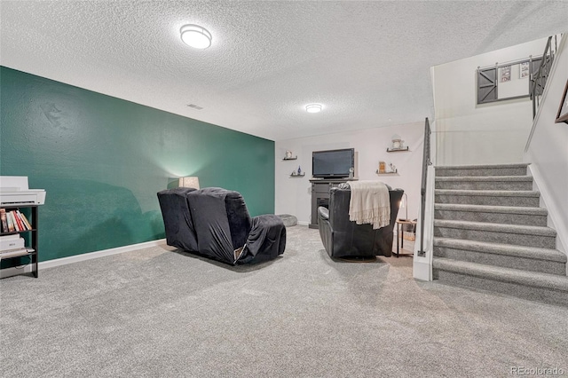 living area with stairs, carpet floors, baseboards, and a textured ceiling