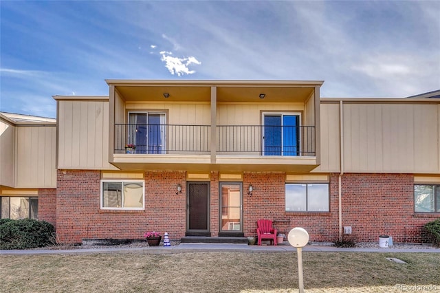 exterior space with a balcony and brick siding