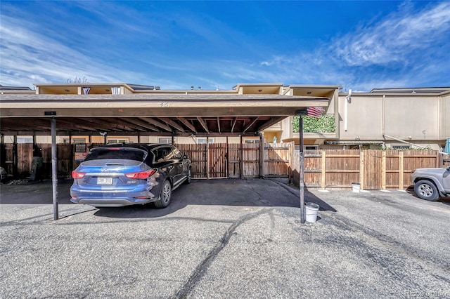 covered parking lot featuring fence