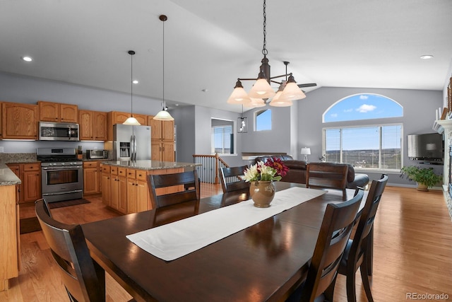 dining space featuring light wood finished floors, a chandelier, recessed lighting, and vaulted ceiling