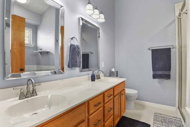 full bathroom featuring double vanity, toilet, baseboards, and a sink