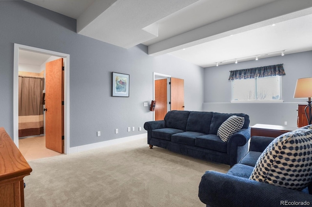 living area with beam ceiling, carpet flooring, rail lighting, and baseboards