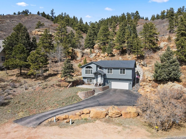 view of front facade with aphalt driveway and a garage