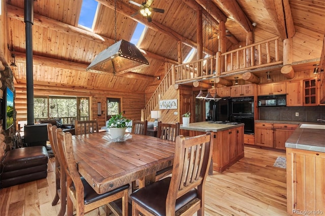 dining space featuring high vaulted ceiling, light wood-type flooring, wood ceiling, and beamed ceiling