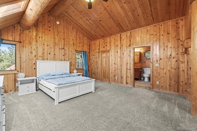 unfurnished bedroom featuring carpet flooring, vaulted ceiling with skylight, wood ceiling, and wooden walls