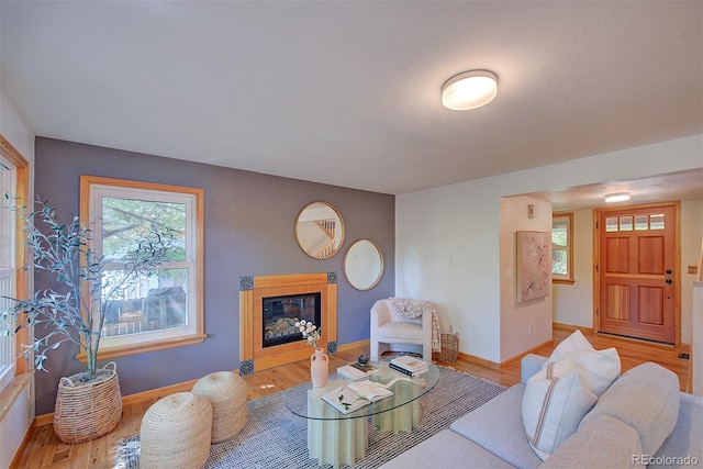 3966 Bosque Ct, Boulder, CO 80301 - living area featuring light wood-type flooring, a glass covered fireplace, and baseboards