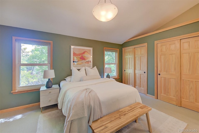 3966 Bosque Ct, Boulder, CO 80301 - bedroom with lofted ceiling, two closets, multiple windows, light colored carpet, and baseboards