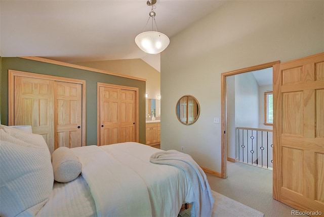 3966 Bosque Ct, Boulder, CO 80301 - bedroom with vaulted ceiling, light carpet, multiple closets, baseboards, and connected bathroom