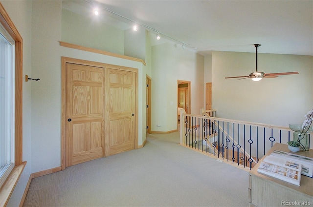 3966 Bosque Ct, Boulder, CO 80301 - corridor with carpet, rail lighting, high vaulted ceiling, baseboards, and an upstairs landing